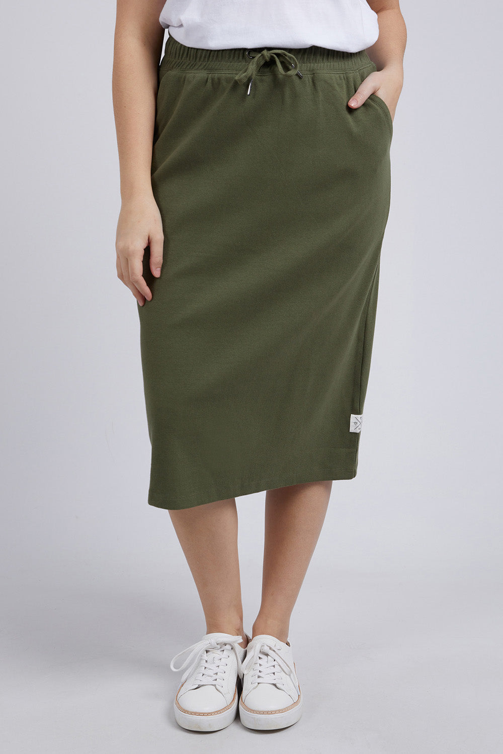 A model wearing the Fundamental Rib Midi Skirt in colour Clover (Green), from the front, cropped image