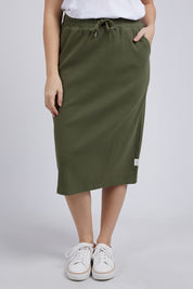 A model wearing the Fundamental Rib Midi Skirt in colour Clover (Green), from the front, cropped image