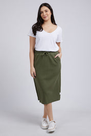 A model wearing the Fundamental Rib Midi Skirt in colour Clover (Green), from the front, showing the whole outfit