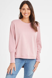 Model Madeline wearing size 10 of the Fundamentals Cosy Divine Crew in colour Dustypnk (Pink), from the front, cropped image