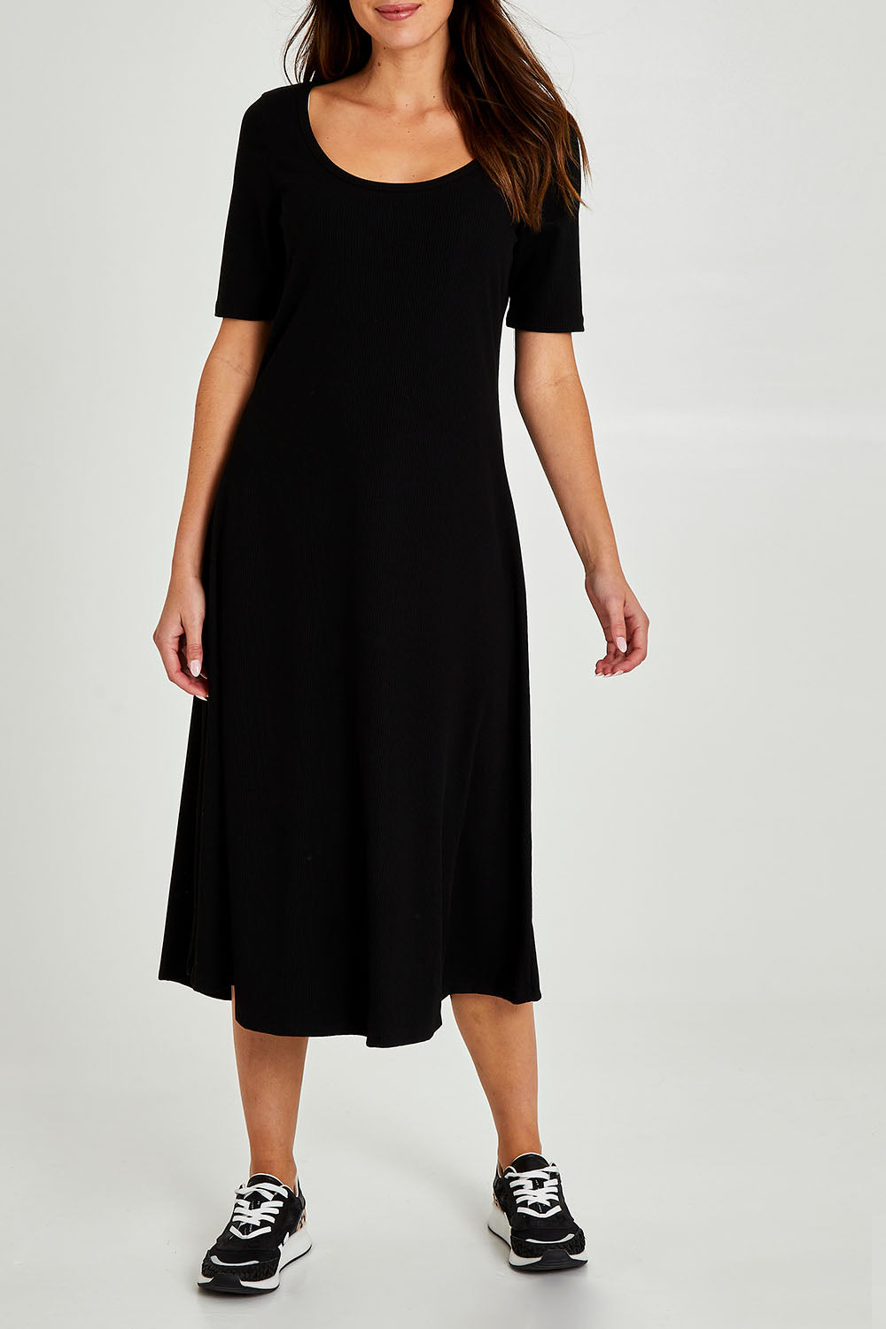 Model Madeline wearing size 10 of the Fundamental Marguerite Dress in colour Black (Black), from the front, cropped image
