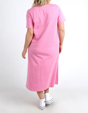 A model wearing the Fundamental Adira Dress in colour Strawberry (Pink), from the back