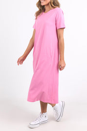 A model wearing the Fundamental Adira Dress in colour Strawberry (Pink), from the front, cropped image