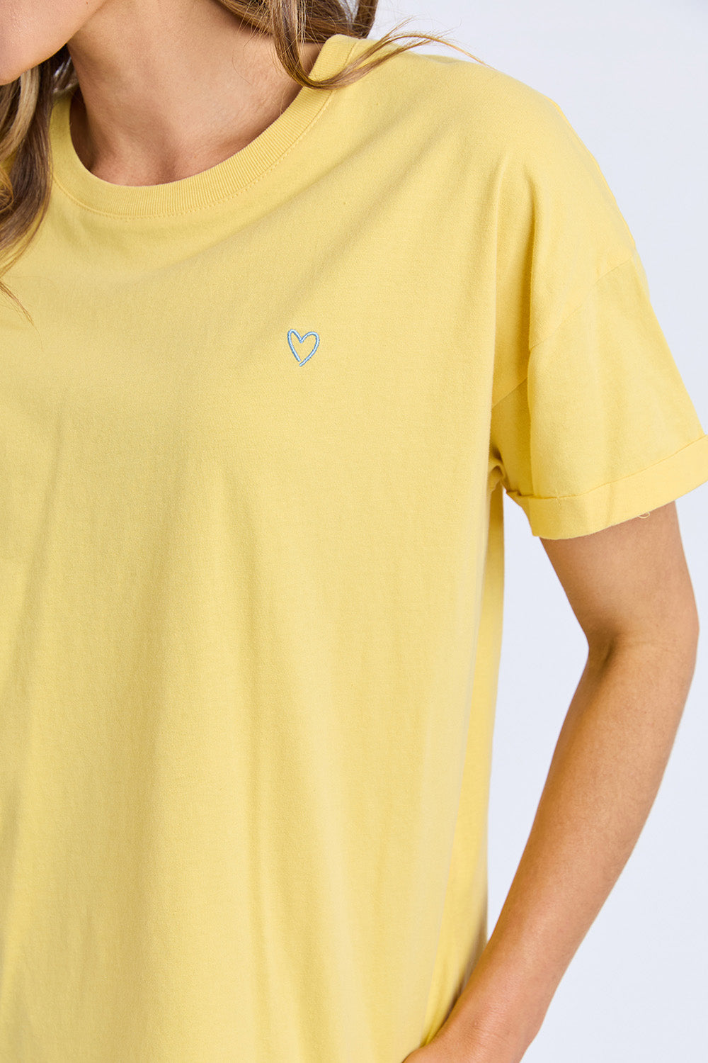A model wearing the Fundamental Halli Cotton Tee in colour Lemon, from the front, cropped image
