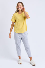 A model wearing the Fundamental Halli Cotton Tee in colour Lemon, from the front, showing the whole outfit