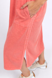 A model wearing the Fundamental Elysian Cotton Dress in colour Watermelon (Red), from the front, cropped image