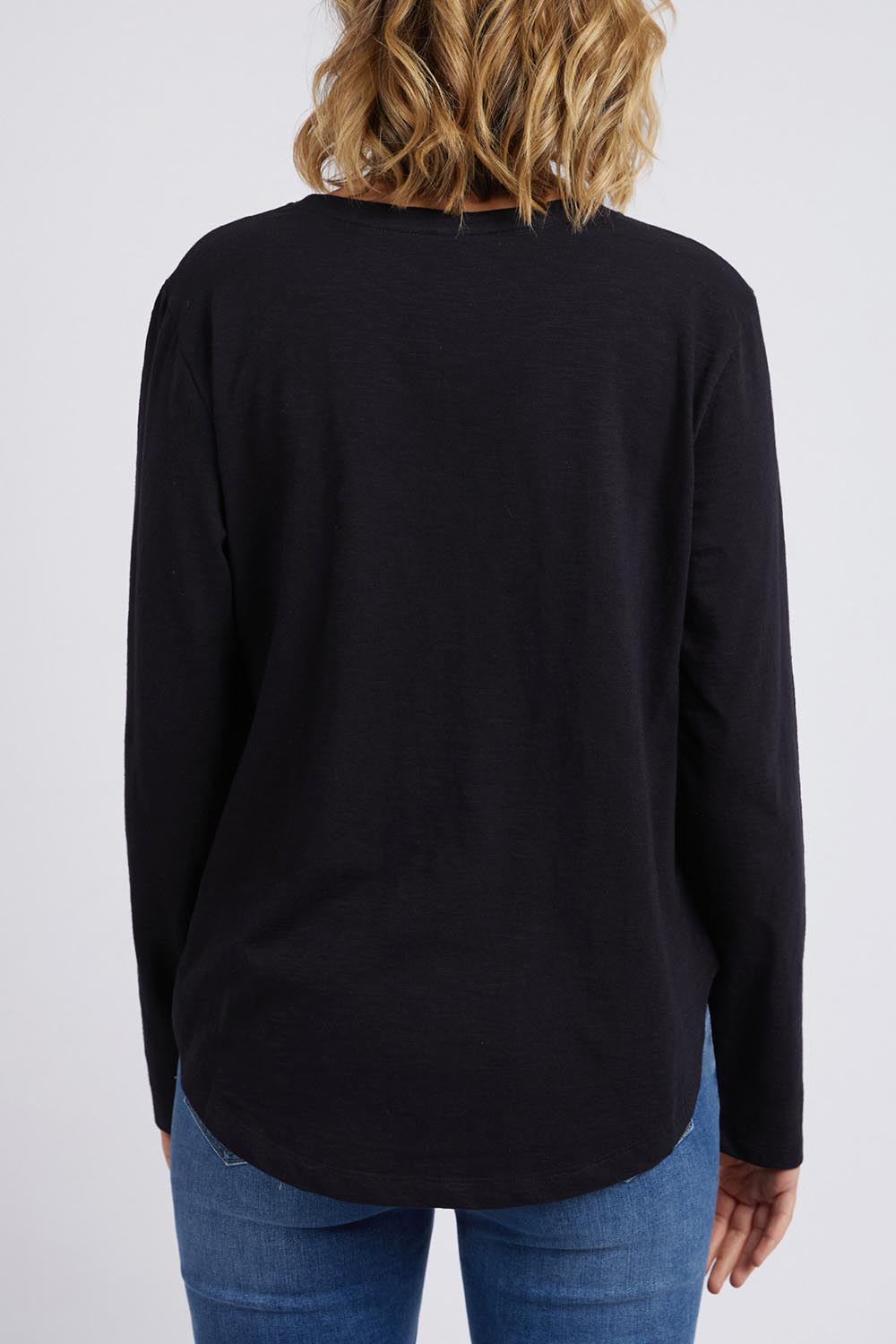 A model wearing the Fundamental Everyday Cotton Long Sleeve Tee in colour Black (Black), from the back