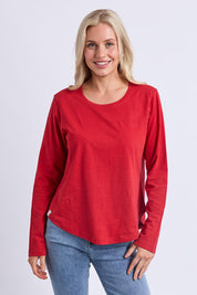 A model wearing the Fundamental Everyday Cotton Long Sleeve Tee in colour Cranberry (Red), from the front, cropped image