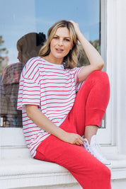 A model wearing the Fundamental Winona Stripe Cotton Tee in colour Redwhite (Red), from the front, showing the whole outfit