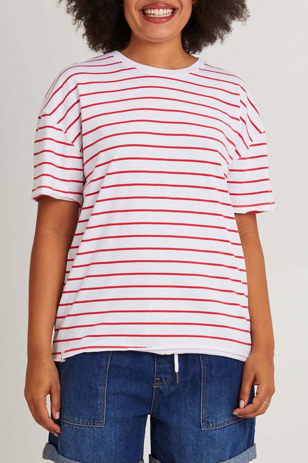 Model Olivia wearing size 10 of the Fundamental Winona Stripe Cotton Tee in colour Redwhite (Red), from the front, cropped image