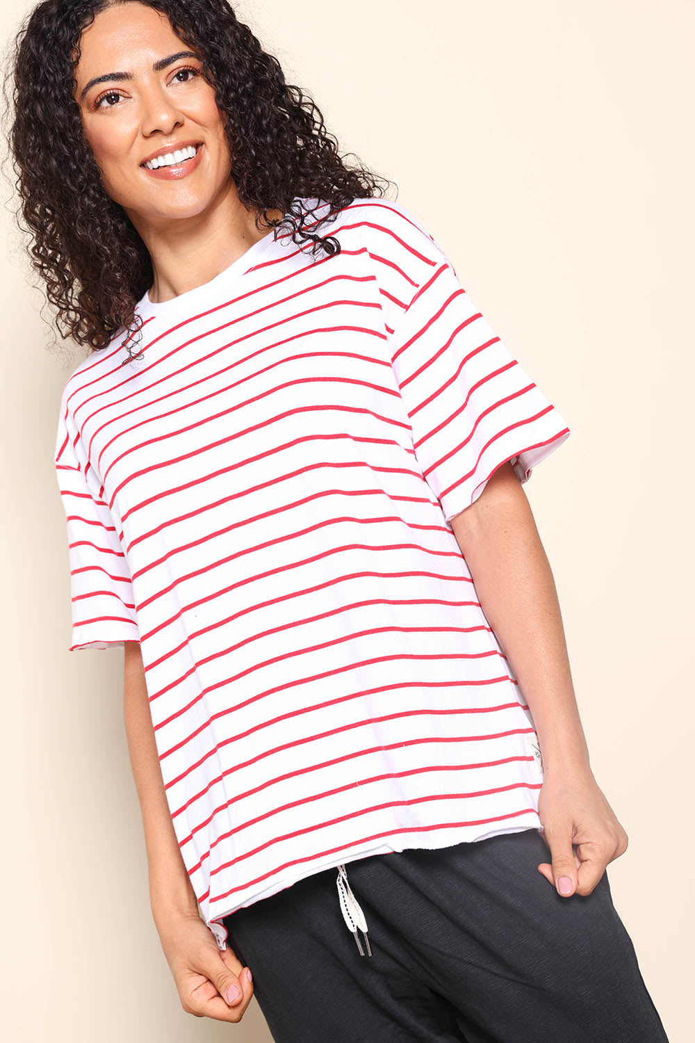 Model Pamelar wearing size 10 of the Fundamental Winona Stripe Cotton Tee - Redwhite in colour Redwhite, from an angle