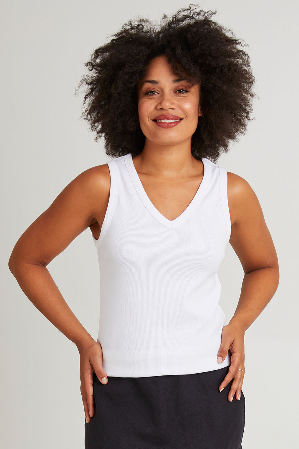 Model Veronica wearing size 10 of the Fundamental Rib Cotton Vee Tank in colour White (White), from the front, cropped image