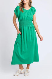 A model wearing the Fundamental Nelle Cotton Midi Dress in colour Pinegreen (Green), from the front, cropped image