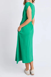 A model wearing the Fundamental Nelle Cotton Midi Dress in colour Pinegreen (Green), from the front, showing the whole outfit