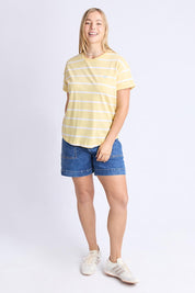 A model wearing the Fundamental Halli Cotton Short Sleeve Tee in colour Bananast, from the front, showing the whole outfit