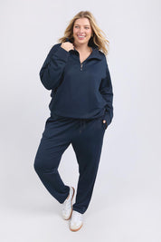 A model wearing the Fundamental Tatum Half Zip Cotton Blend Sweat in colour Navy (Blue), from the front, showing the whole outfit
