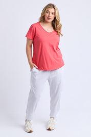A model wearing the Fundamental Pima Cotton Vee Tee in colour Cayenne (Red), from the front, showing the whole outfit