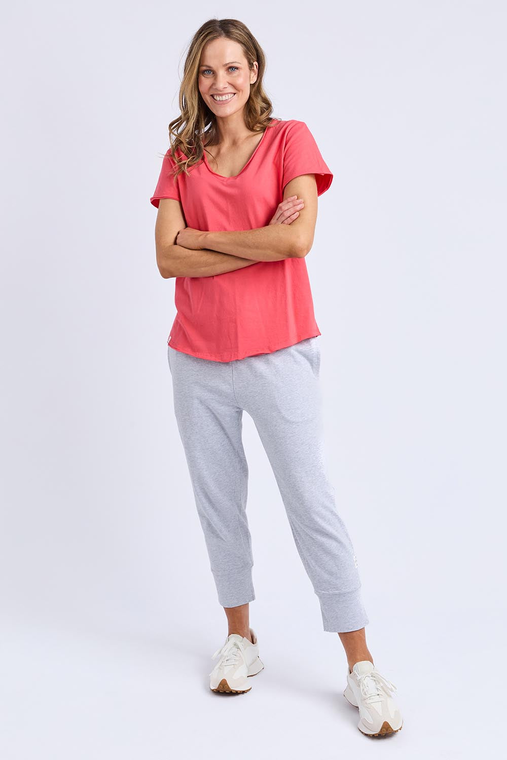 A model wearing the Fundamental Pima Cotton Vee Tee in colour Cayenne (Red), from the front, showing the whole outfit