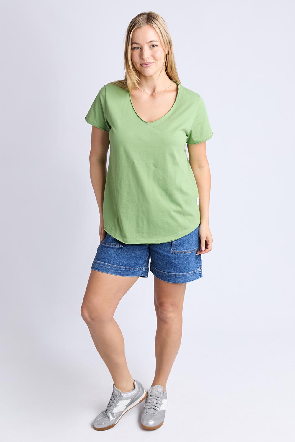 A model wearing the Fundamental Pima Cotton Vee Tee in colour Forest (Green), from the front, showing the whole outfit