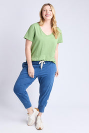 A model wearing the Fundamental Pima Cotton Vee Tee in colour Forest (Green), from the front, showing the whole outfit