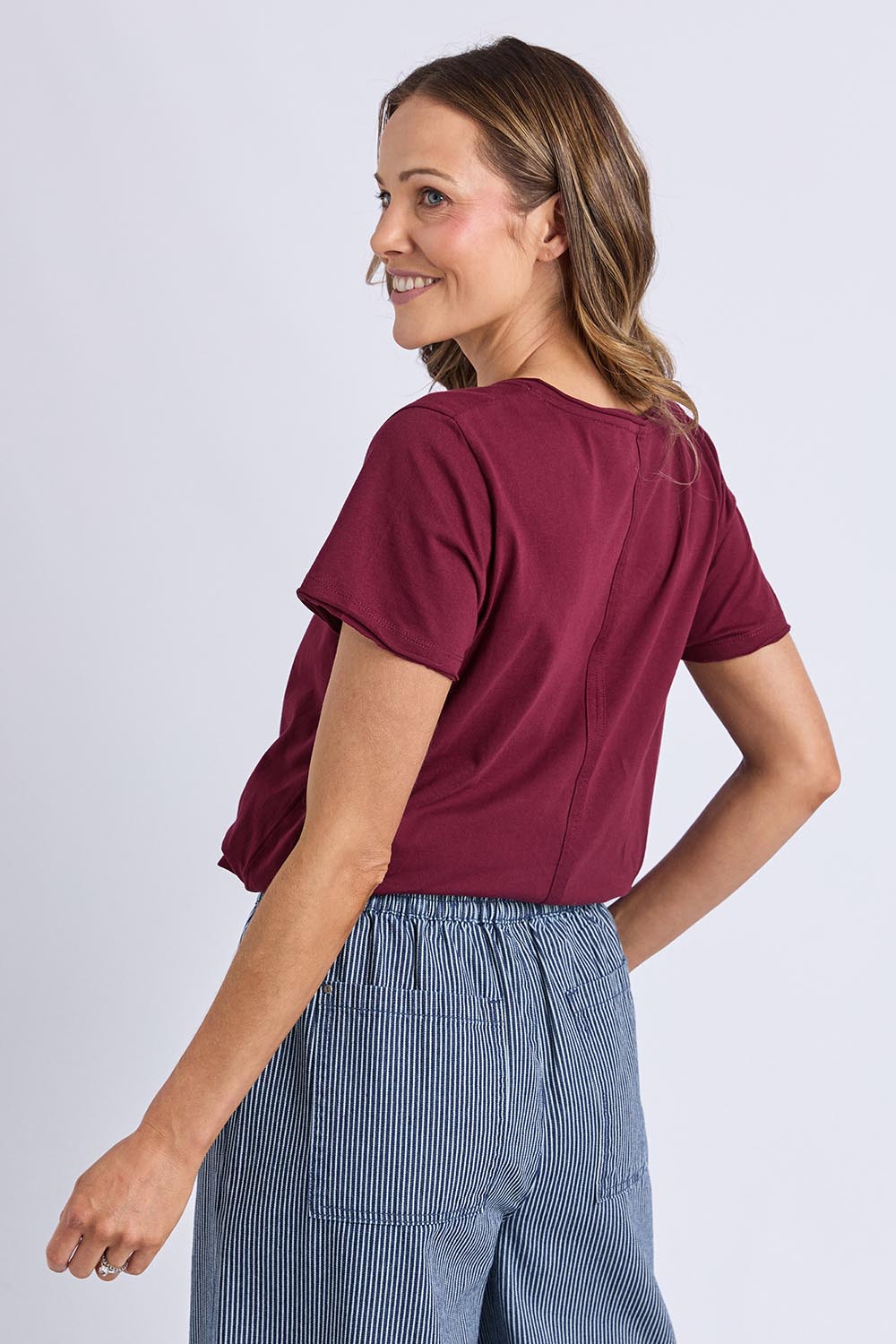 A model wearing the Fundamental Pima Cotton Vee Tee in colour Plum (Purple), from the back