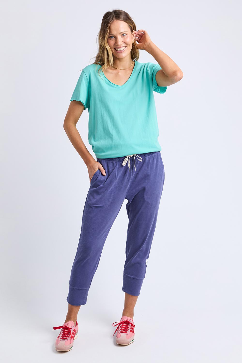 A model wearing the Fundamental Pima Cotton Vee Tee in colour Poolblue (Blue), from the front, showing the whole outfit