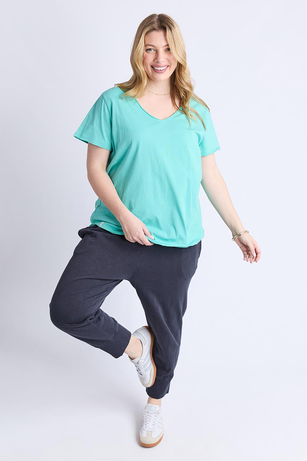 A model wearing the Fundamental Pima Cotton Vee Tee in colour Poolblue (Blue), from the front, showing the whole outfit