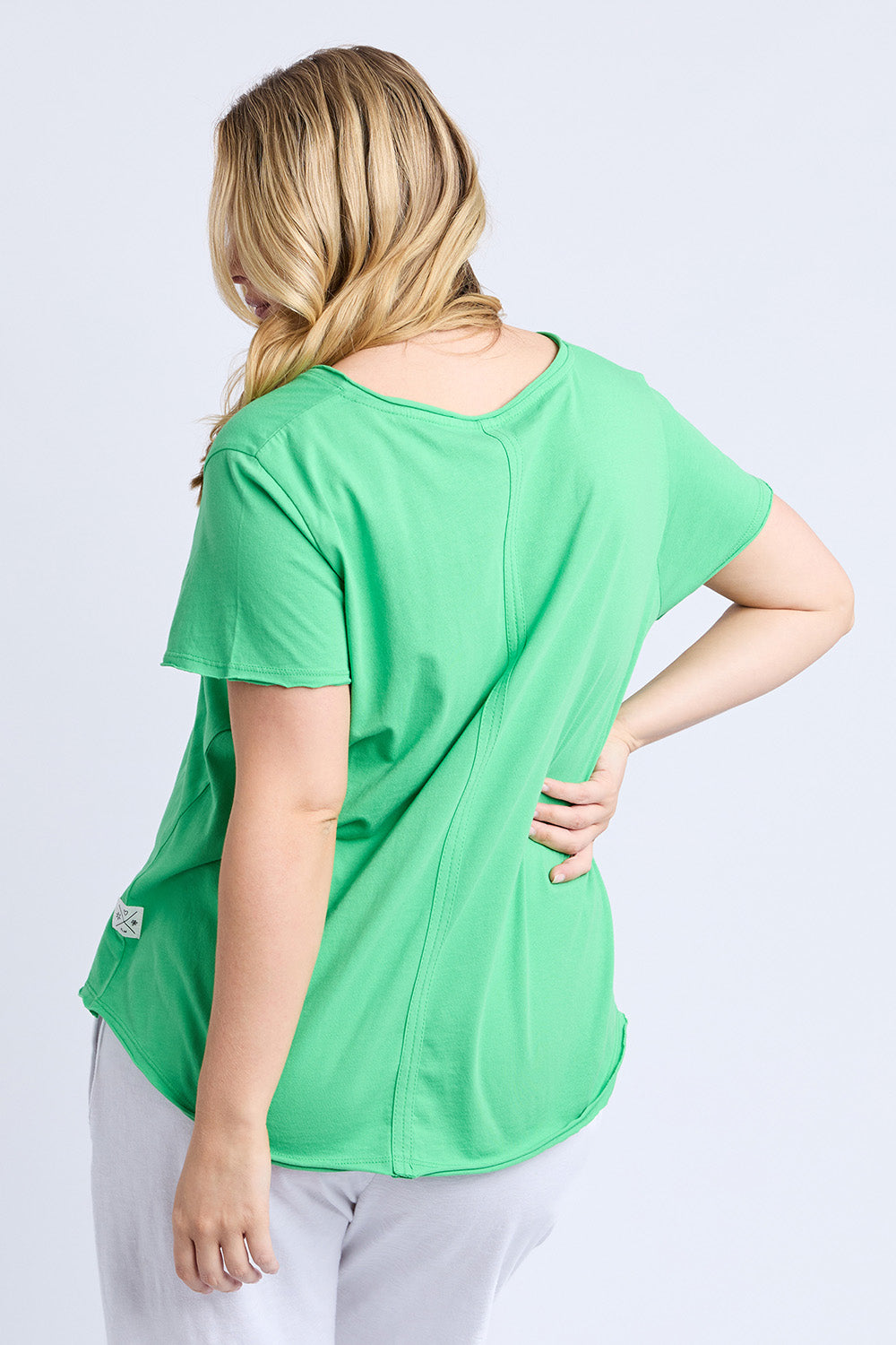 A model wearing the Fundamental Pima Cotton Vee Tee in colour Springgree (Green), from the back