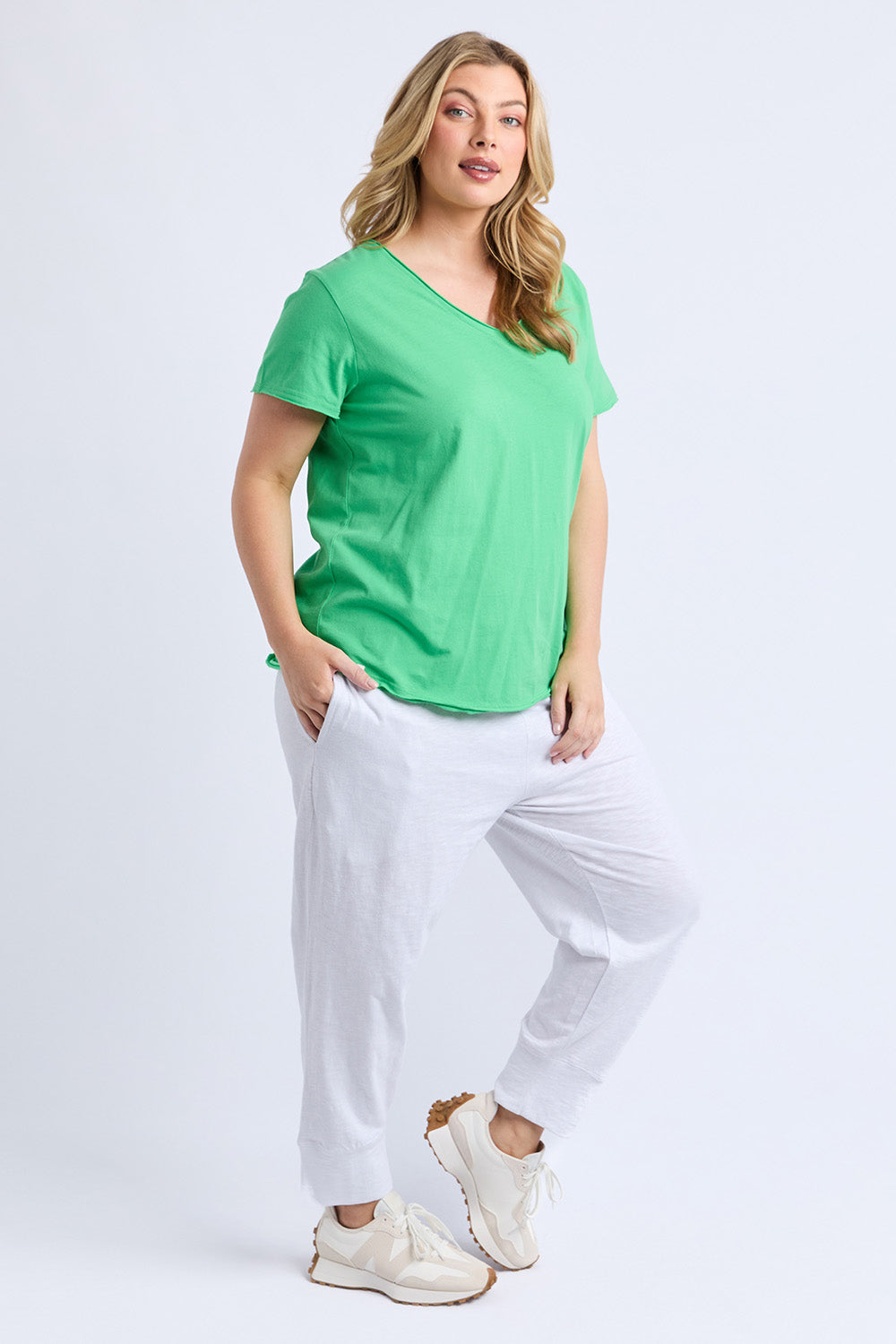 A model wearing the Fundamental Pima Cotton Vee Tee in colour Springgree (Green), from the front, showing the whole outfit