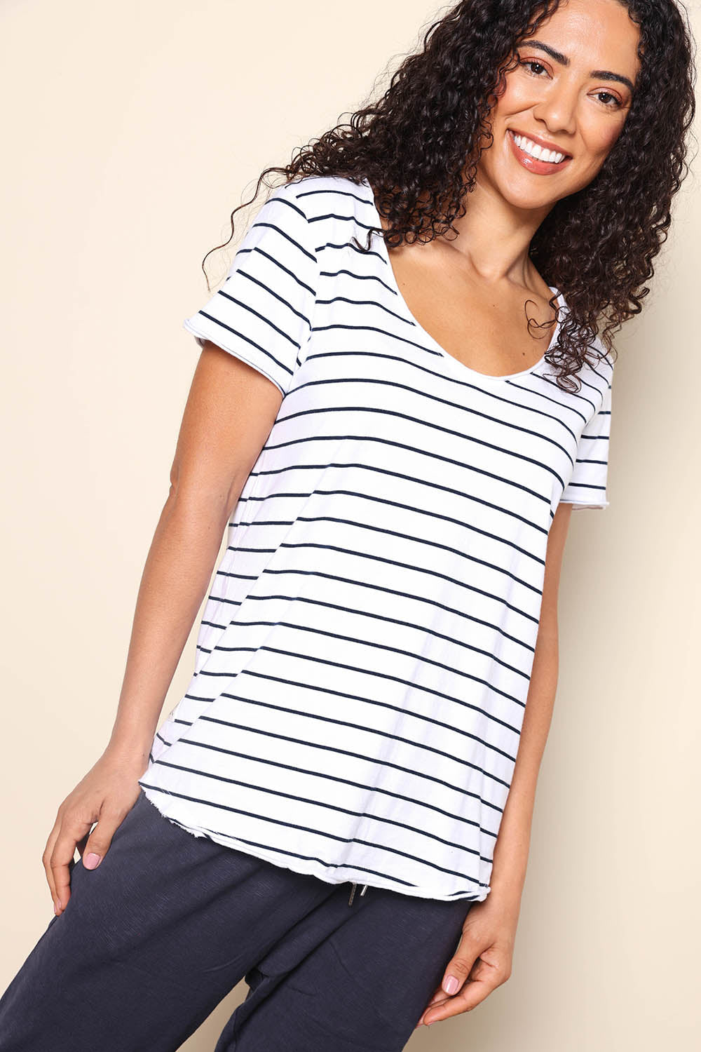 Model Pamelar wearing size 10 of the Fundamental Pima Cotton Stripe Vee Tee - Whitenavy in colour Whitenavy, from an angle