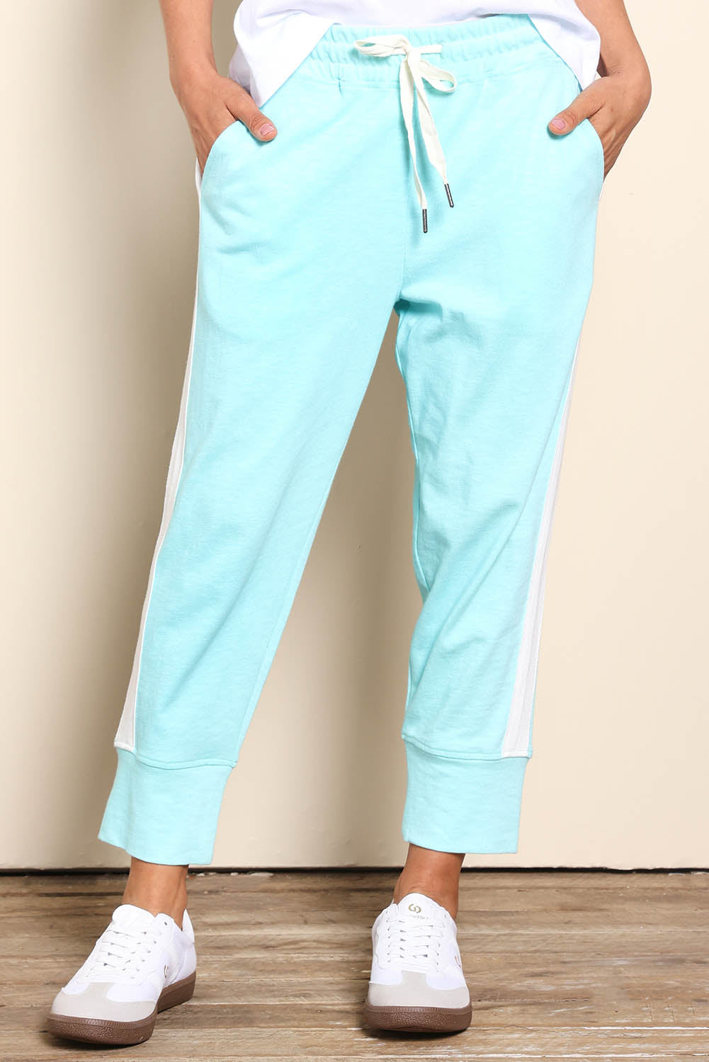 Model Pamelar wearing size 10 of the Fundamental Brunch Cotton Side Tape Pant – Tonicblue in colour Tonicblue, in a cropped view