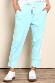 Model Pamelar wearing size 10 of the Fundamental Brunch Cotton Side Tape Pant – Tonicblue in colour Tonicblue, in a cropped view