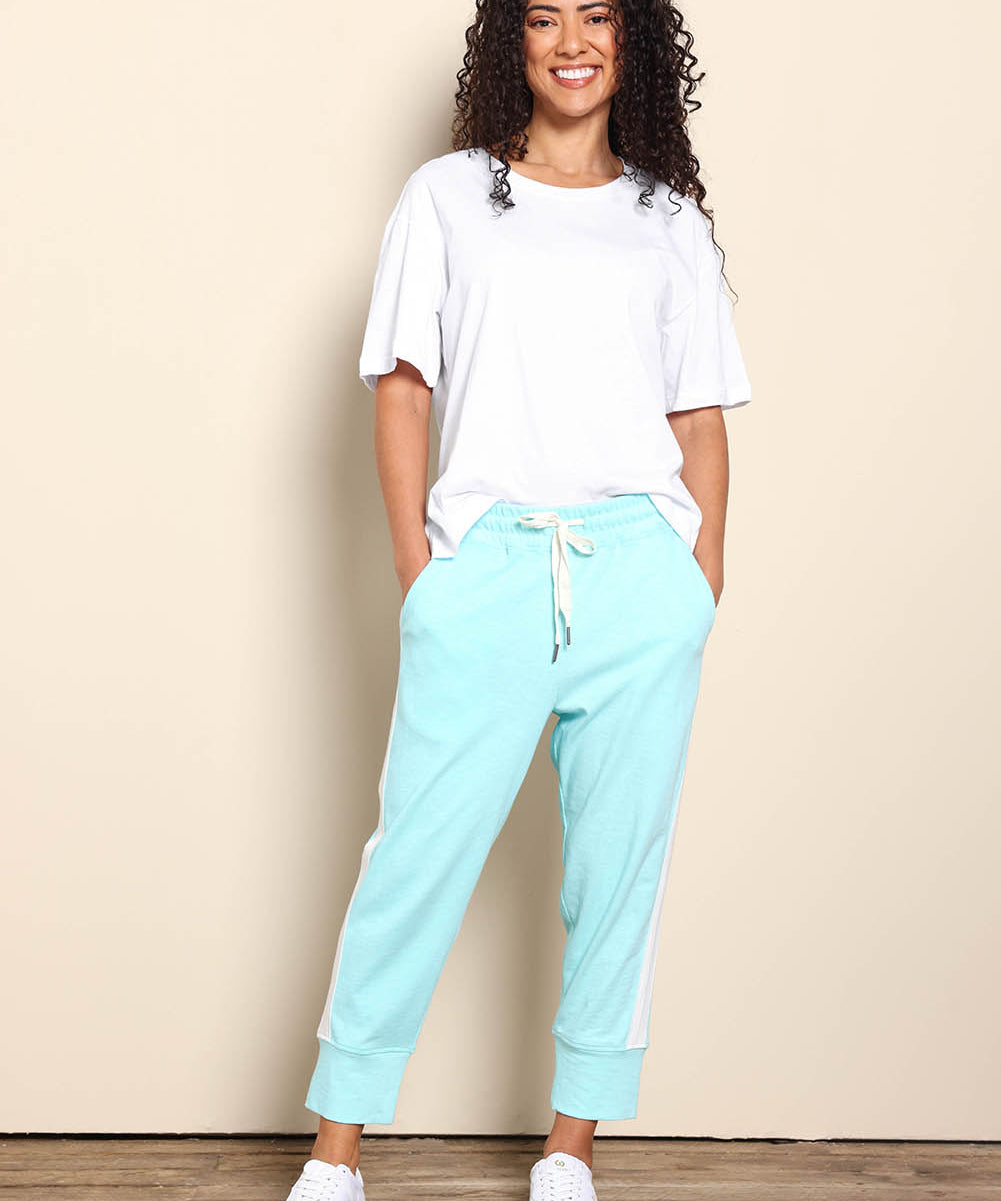 Model Pamelar wearing size 10 of the Fundamental Brunch Cotton Side Tape Pant – Tonicblue in colour Tonicblue, from the front