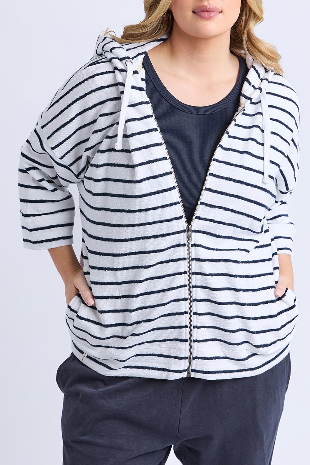 A model wearing the Fundamental Beachy Cotton Hoodie in colour Whitenavy (White), from the front, cropped image