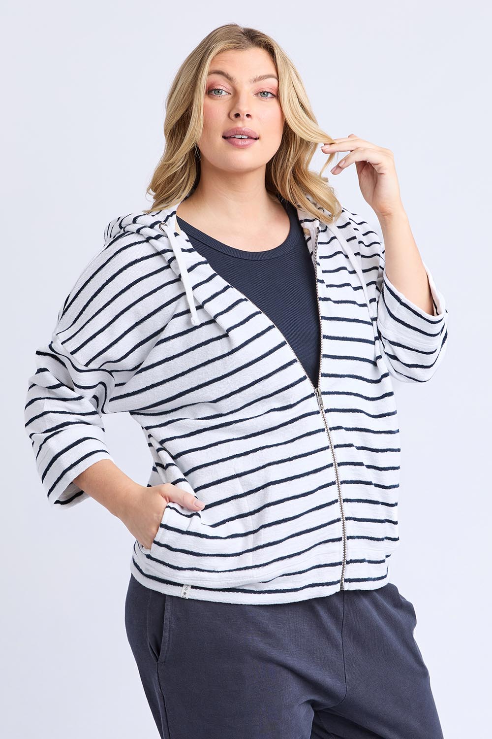 A model wearing the Fundamental Beachy Cotton Hoodie in colour Whitenavy (White), from the front, cropped image