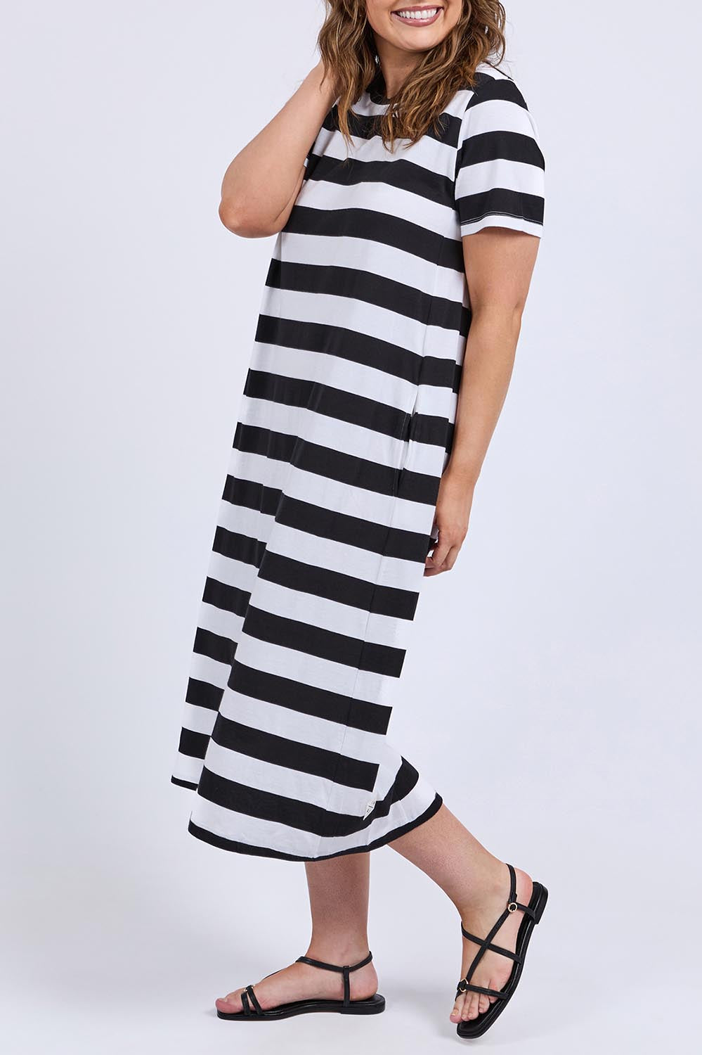 A model wearing the Fundamental Adira Cotton Dress in colour Blackwhite (Black), from the front, cropped image