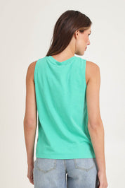 Model Madeline wearing size 10 of the Fundamental Elysian Cotton Tank in colour Gumdrop (Green), from the back