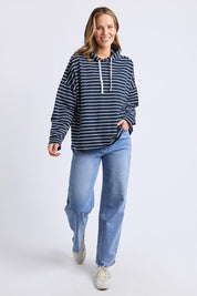 A model wearing the Fundamental Rhea Stripe Cotton Hoodie in colour Navystripe (Blue), from the front, showing the whole outfit