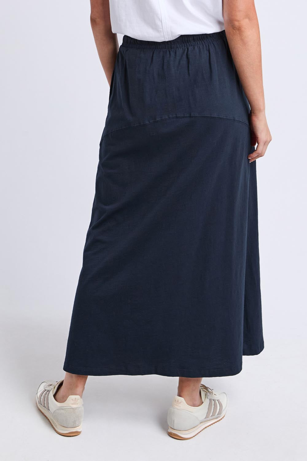 Model Genericm wearing size sample of the Fundamental Meadow Cotton Skirt – Navy in colour Navy, from the back