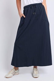 Model Genericm wearing size sample of the Fundamental Meadow Cotton Skirt – Navy in colour Navy, in a cropped view