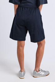 Model Genericm wearing size sample of the Fundamental Summer Fleece Cotton Short – Navy in colour Navy, from the back