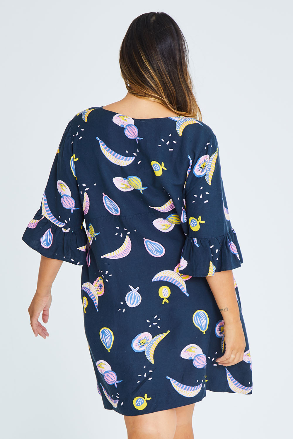 Model Palatina wearing size 16 of the Fruity Tootie Dress in colour Navymulti (Blue), from the back