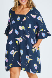 Model Palatina wearing size 16 of the Fruity Tootie Dress in colour Navymulti (Blue), from the front, cropped image