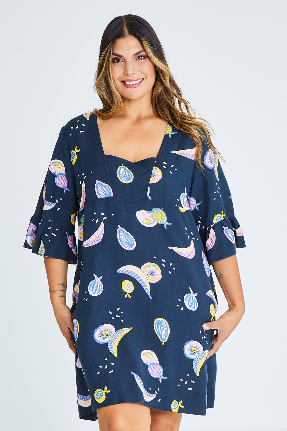 Model Palatina wearing size 16 of the Fruity Tootie Dress in colour Navymulti (Blue), from the front, cropped image