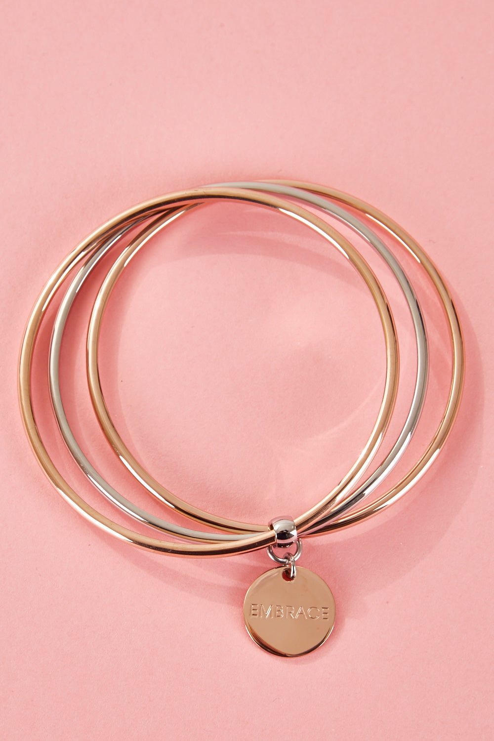 A model wearing the Triple Bangle Embracelet in colour Steel Rose (Metallics), from the front, showing the whole outfit