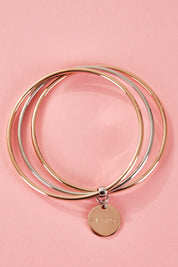A model wearing the Triple Bangle Embracelet in colour Steel Rose (Metallics), from the front, showing the whole outfit