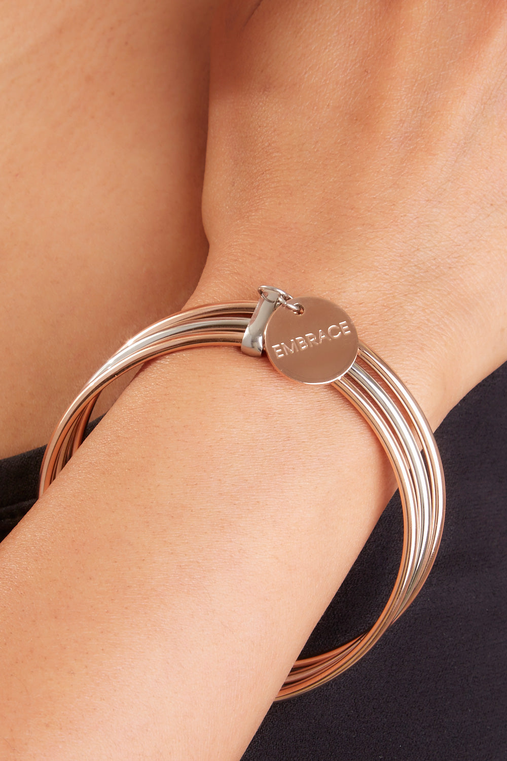 A model wearing the Triple Bangle Embracelet in colour Steel Rose (Metallics), from the front, showing the whole outfit