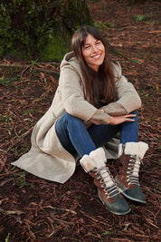 A model wearing the Orica Hi Waterproof Leather Boot in colour Oak, from the front, showing the whole outfit
