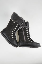A model wearing size 7 of the Orica Hi Waterproof Leather Boot in colour Darkgrey (Grey), from the front, showing the whole outfit