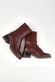 A model wearing size 37 of the Finton Lace Up Boot in colour Redwood, from the front, showing the whole outfit